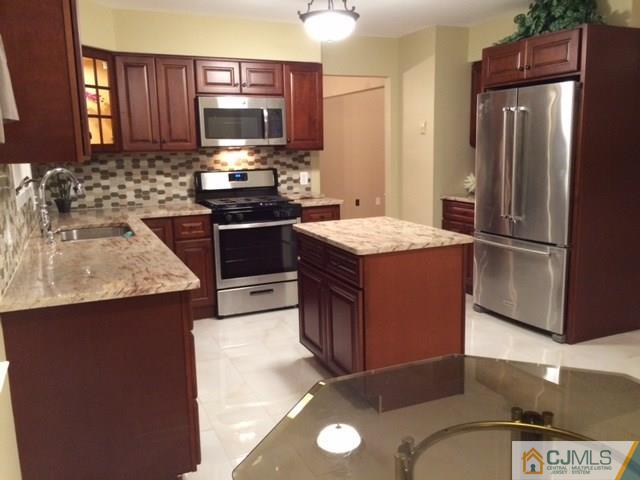 12 Sinclair Road Edison, NJ 08820 - Photo 12 of 18 a kitchen with stainless steel appliances granite countertop a sink stove and refrigerator