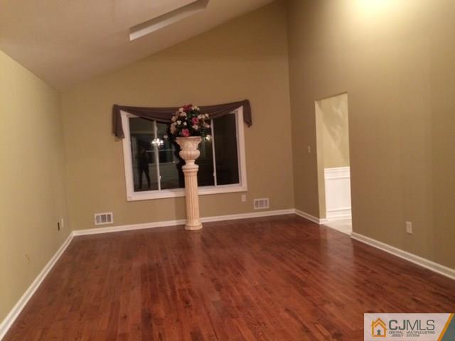 12 Sinclair Road Edison, NJ 08820 - Photo 3 of 18 a view of an empty room with wooden floor and a window
