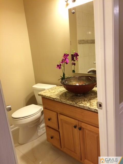 12 Sinclair Road Edison, NJ 08820 - Photo 4 of 18 a bathroom with a granite countertop toilet and a sink