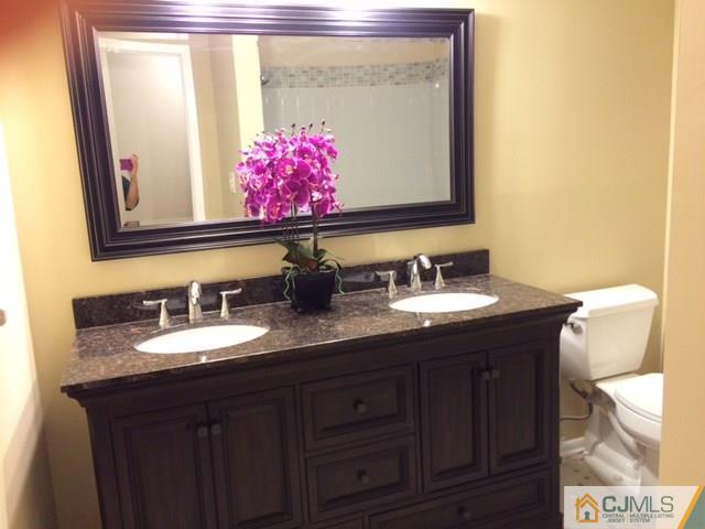 12 Sinclair Road Edison, NJ 08820 - Photo 5 of 18 a bathroom with a granite countertop sink and a mirror