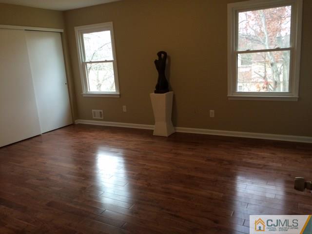 12 Sinclair Road Edison, NJ 08820 - Photo 10 of 18 an empty room with wooden floor and windows