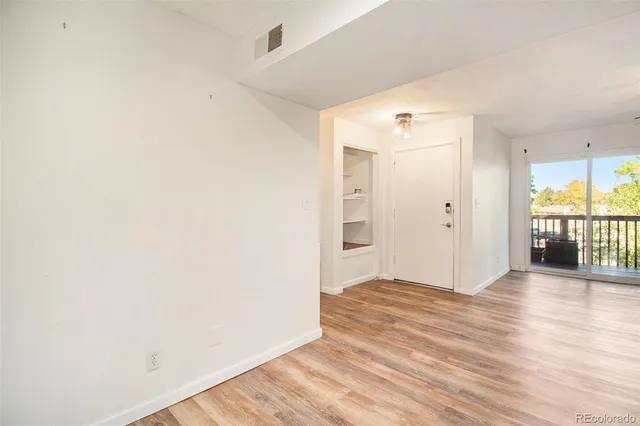 an empty room with wooden floor and a window