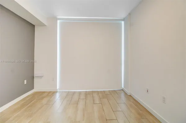 a view of an empty room with wooden floor