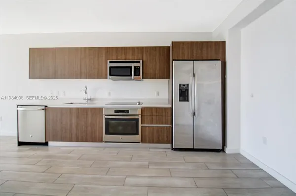 a kitchen with stainless steel appliances a stove a microwave and a refrigerator