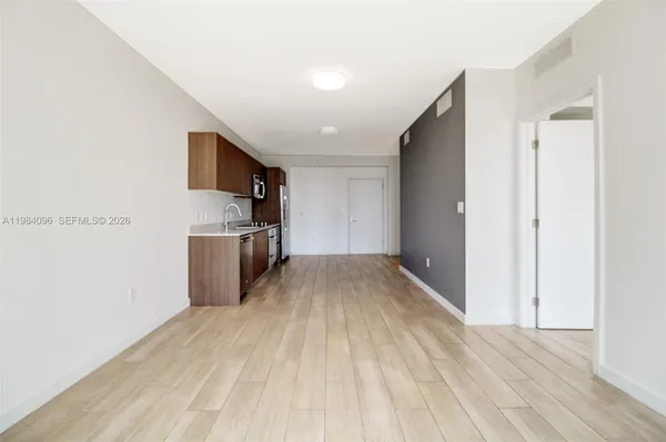 a view of empty room with wooden floor
