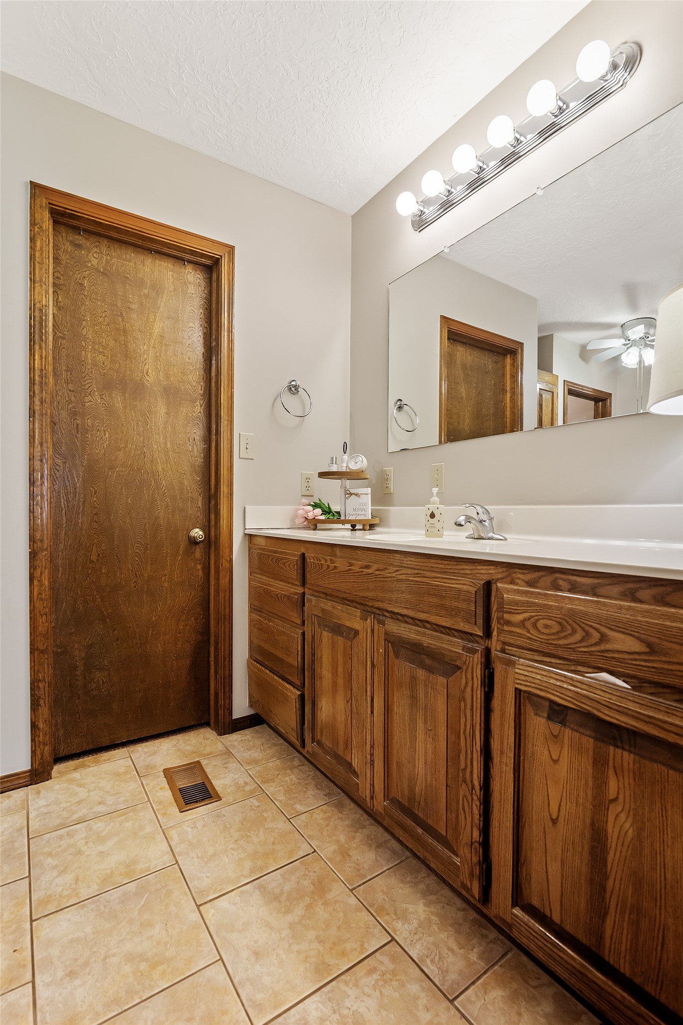 9644 19th Road Nowata, OK 74048 - Photo 15 of 36 Bathroom vanity with wood-finish cabinetry, white countertop, and integrated sink