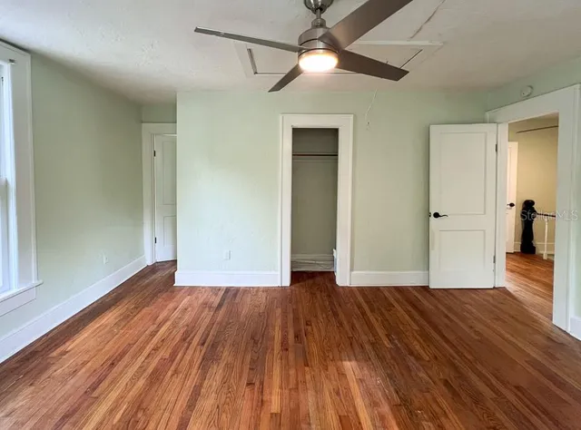 a view of empty room with wooden floor
