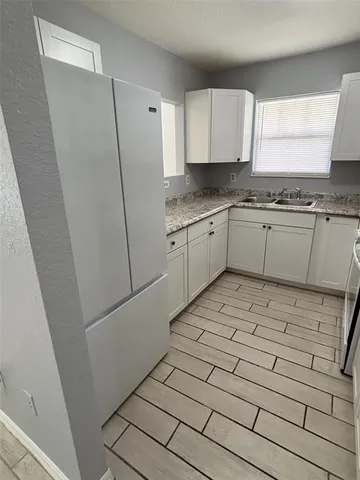 a kitchen with granite countertop white cabinets and white appliances