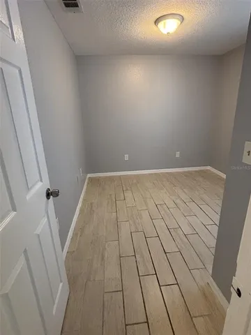 en empty room with wooden floor and white walls