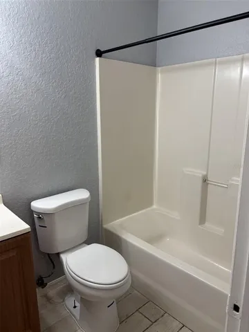 a white toilet sitting next to a bath tub