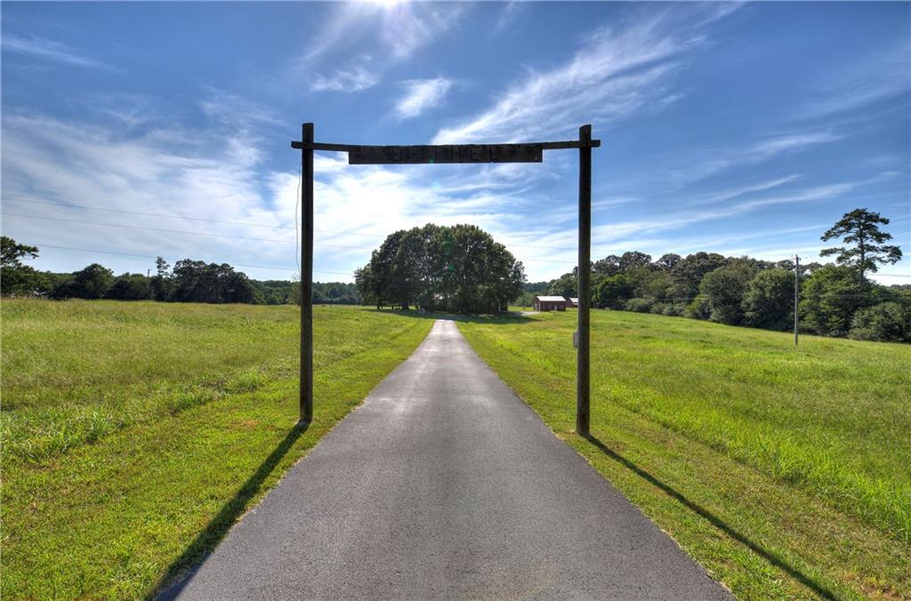 a view of a pathway both side of grassy field with ocean view