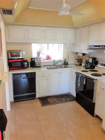 a kitchen with granite countertop a stove sink and cabinets