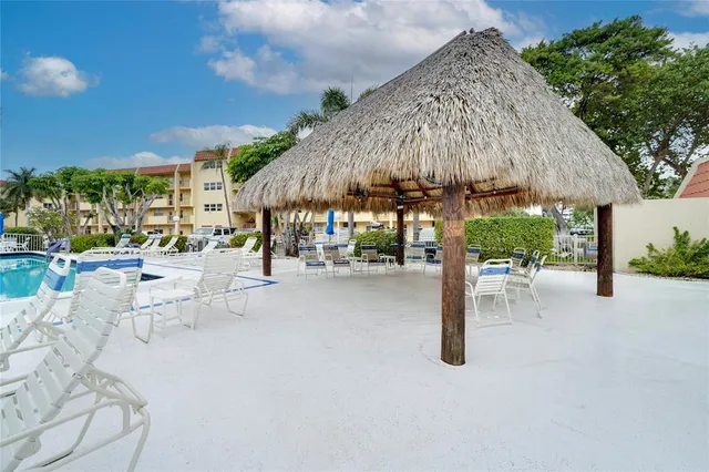 a view of a patio with a table and chairs under an umbrella