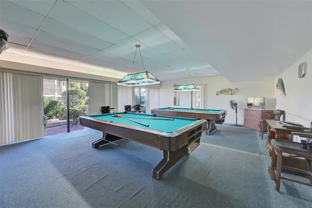 a room with pool table and windows