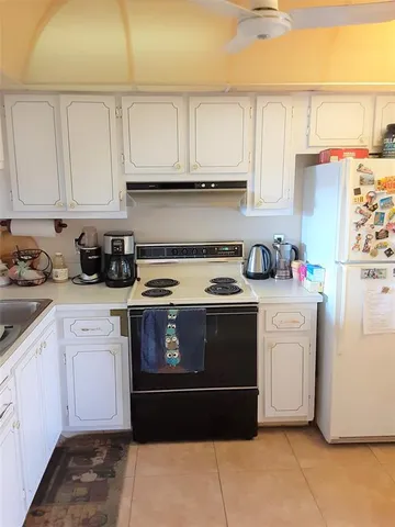 a kitchen with white cabinets and white appliances