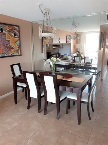 a dining area with stainless steel appliances a table chairs and a kitchen view