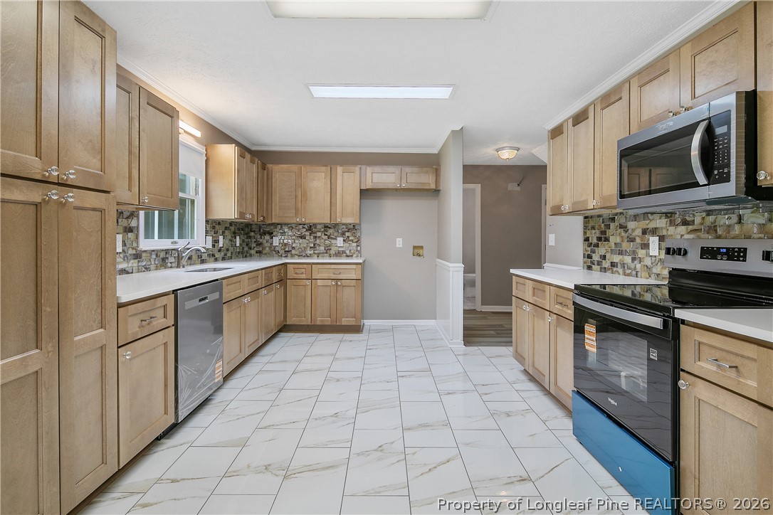 6062 Midus Street Hope Mills, NC 28348 - Photo 12 of 49 a kitchen with stainless steel appliances a sink cabinets and microwave