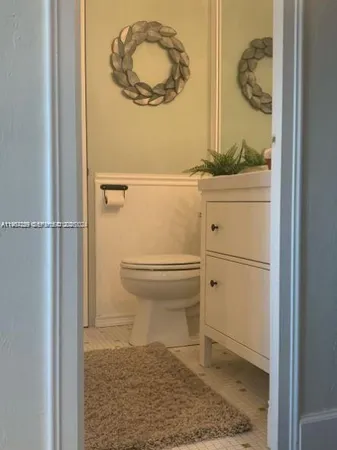a bathroom with a toilet and a mirror