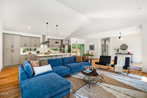 a living room with furniture kitchen view and a rug