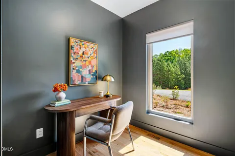 a view of a workspace with furniture and a window