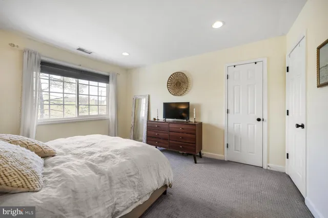 a bedroom with a large bed and a window
