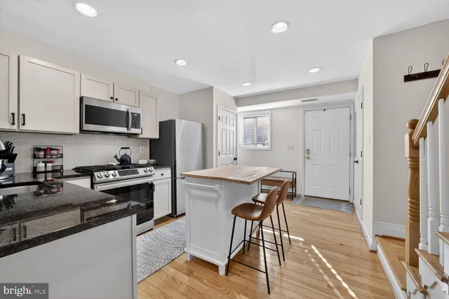 a kitchen with stainless steel appliances granite countertop a refrigerator stove microwave and sink