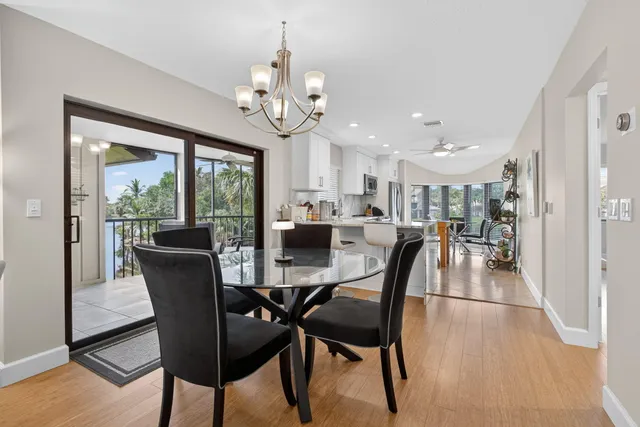 a view of a dining room and livingroom view with furniture wooden floor and chandelier