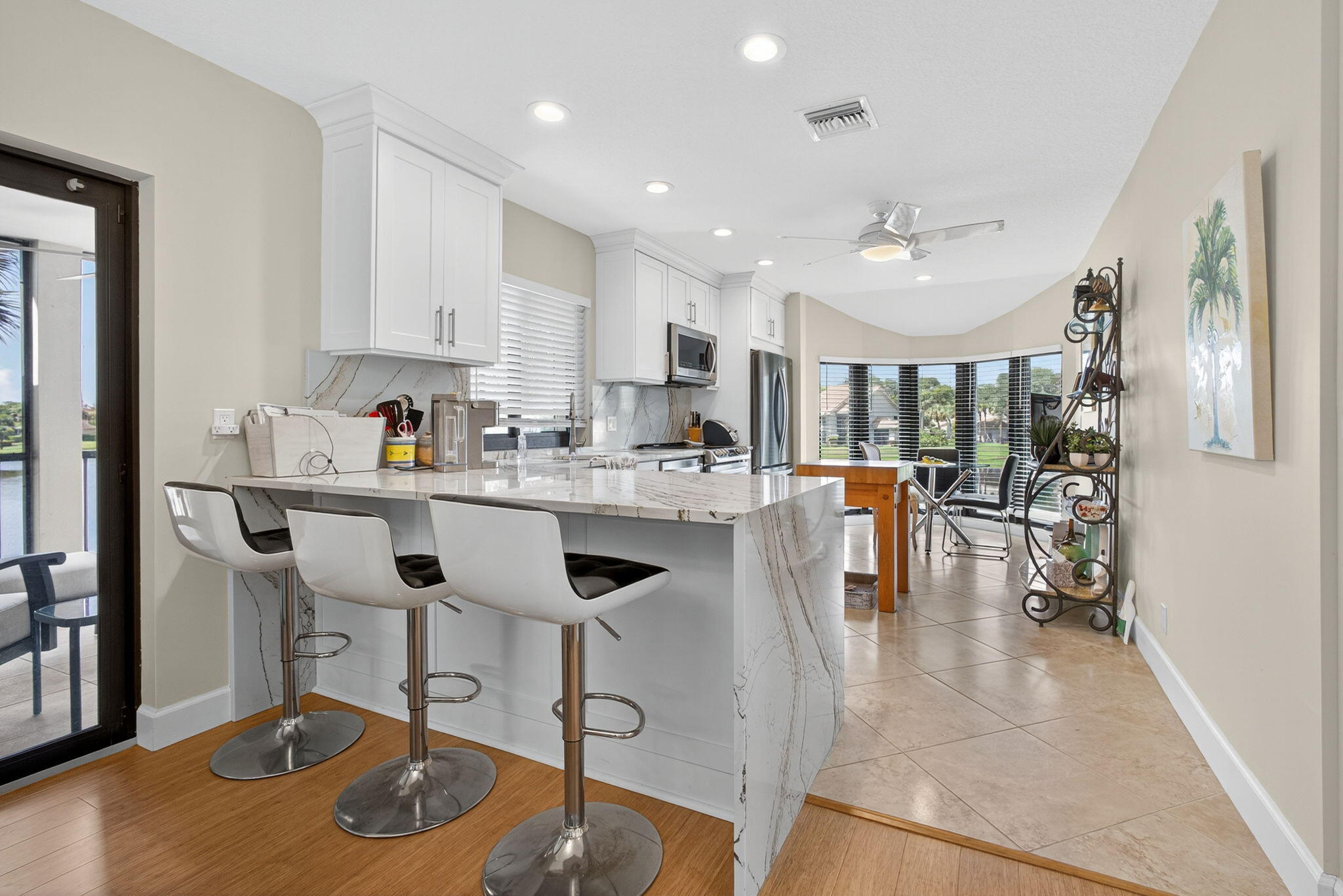16941 Waterbend Drive, Unit 252 Jupiter, FL 33477 - Photo 12 of 34 a kitchen with stainless steel appliances granite countertop a table chairs refrigerator and microwave