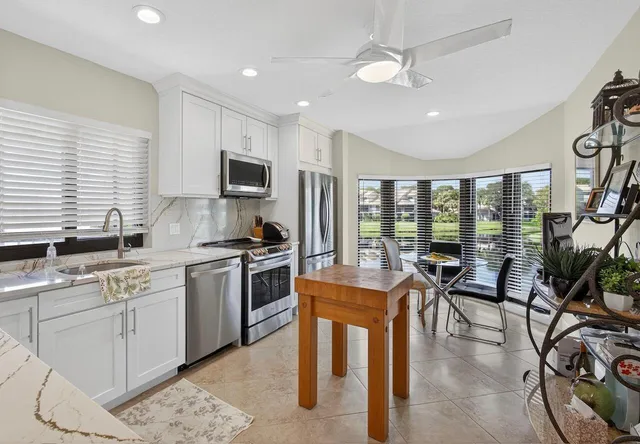 a kitchen with stainless steel appliances granite countertop sink stove top oven and cabinets