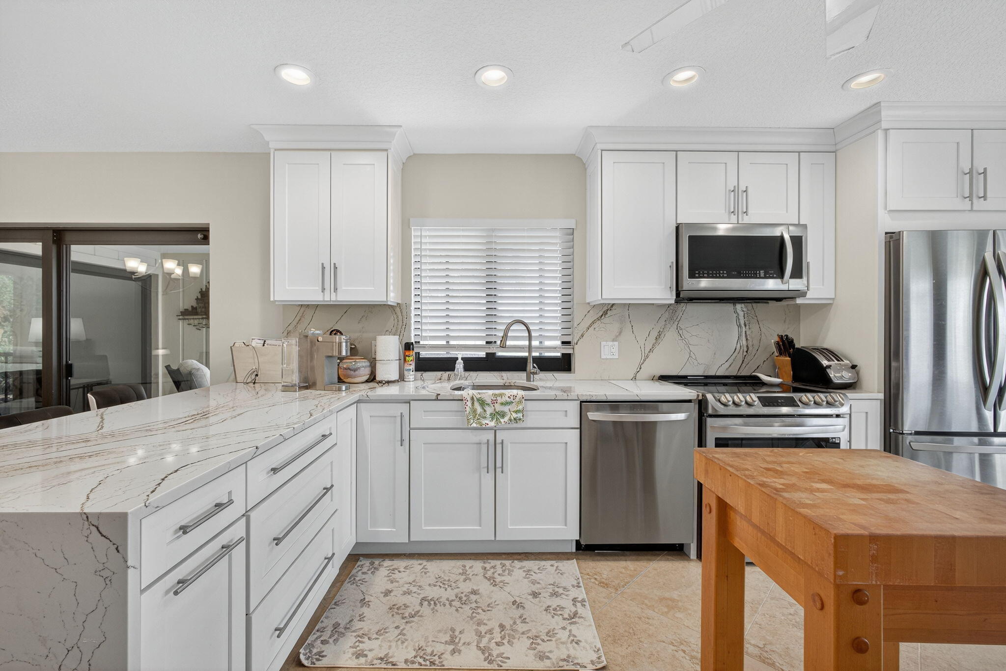 16941 Waterbend Drive, Unit 252 Jupiter, FL 33477 - Photo 14 of 34 a kitchen with a stove a sink and a microwave