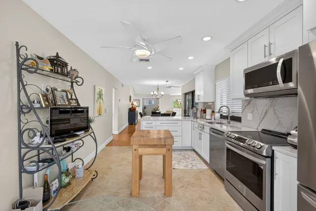 a kitchen with stainless steel appliances kitchen island granite countertop a stove and a sink