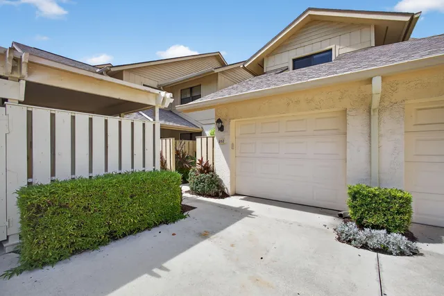 a backyard of a house with lots of green space and glass windows