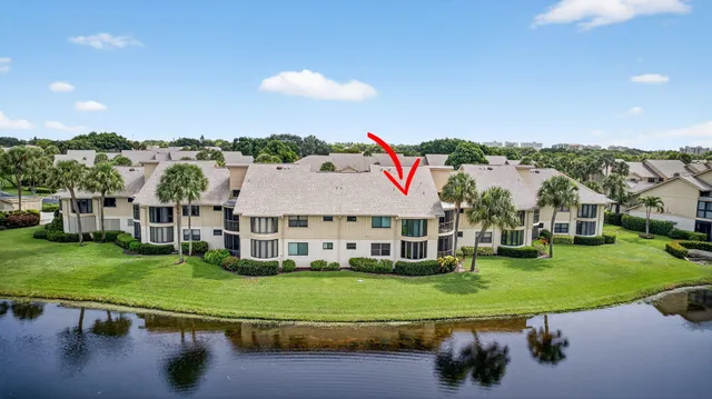 a view of a big house with a big yard and large trees