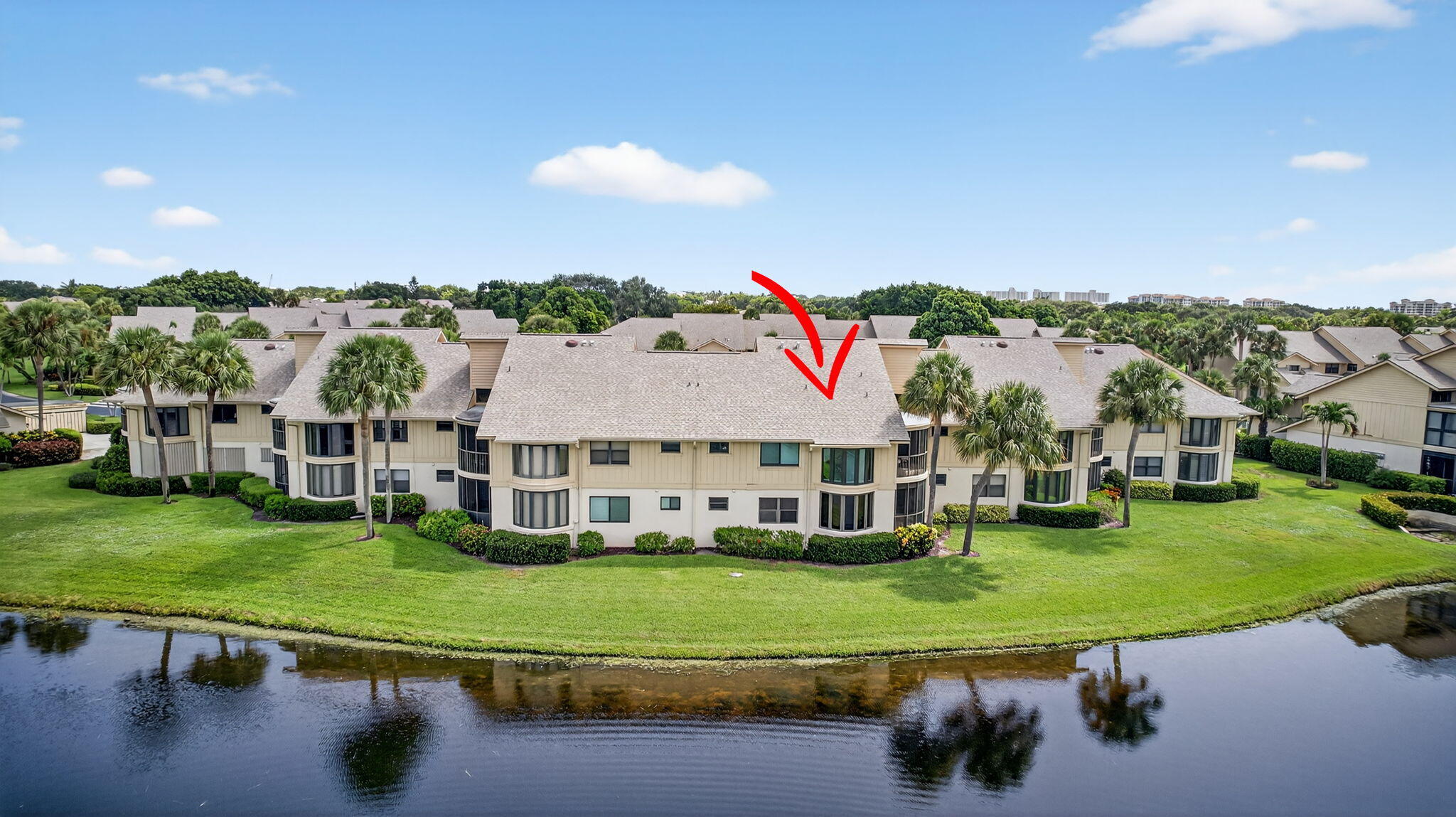 16941 Waterbend Drive, Unit 252 Jupiter, FL 33477 - Photo 32 of 34 a view of a big house with a big yard and large trees