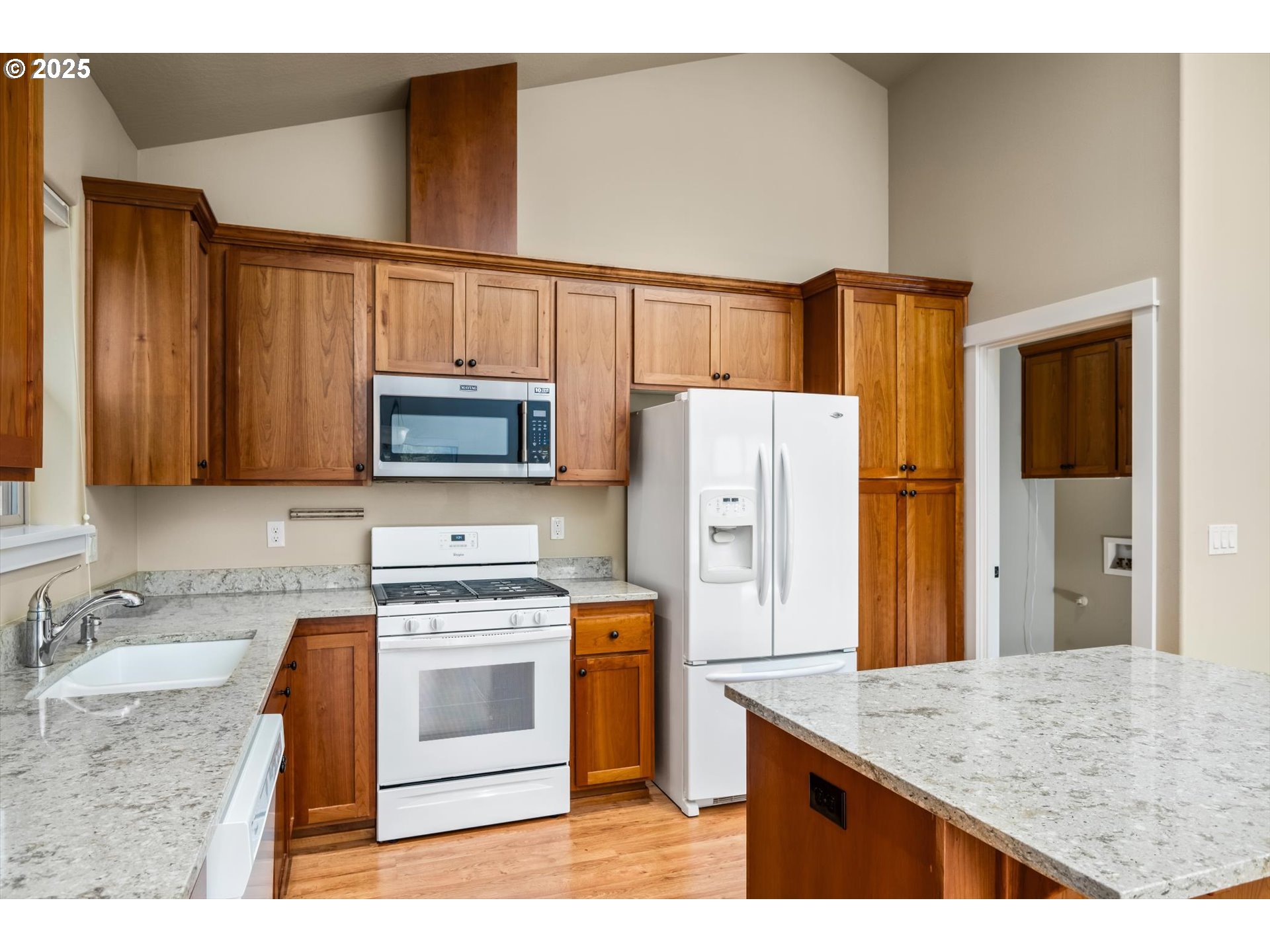 3768 Pachysandra Place Eugene, OR 97402 - Photo 15 of 41 a kitchen with stainless steel appliances granite countertop a refrigerator a stove and a sink with wooden floors