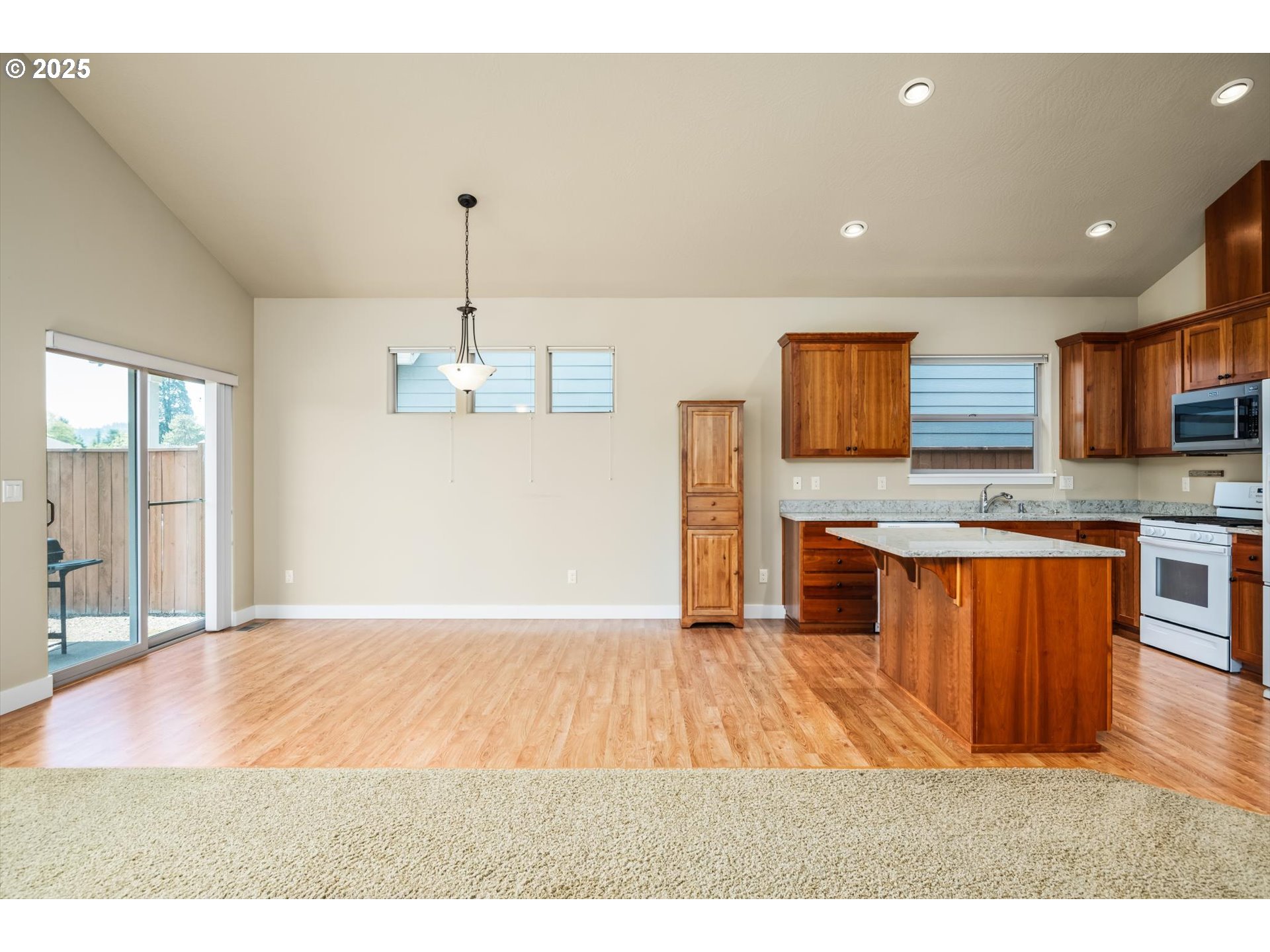 3768 Pachysandra Place Eugene, OR 97402 - Photo 8 of 41 a kitchen with stainless steel appliances granite countertop a sink a stove a refrigerator cabinets and living room view