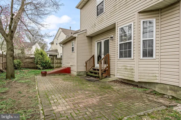 a view of a house with a yard and a bench