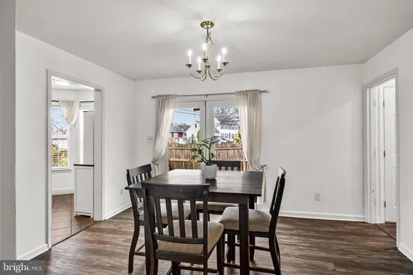 a view of a dining room with furniture a chandelier and wooden floor