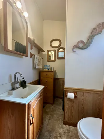a bathroom with a toilet sink and mirror
