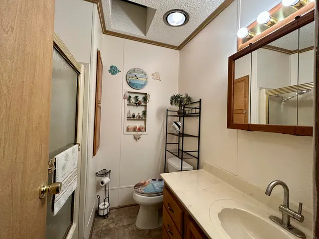 a bathroom with a granite countertop toilet sink and mirror