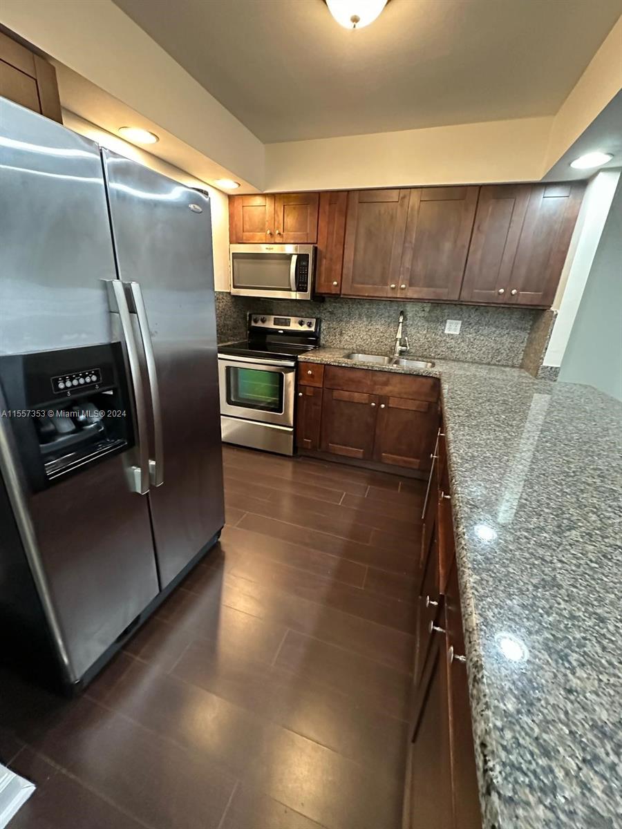 a kitchen with stainless steel appliances wooden cabinets a refrigerator and a stove