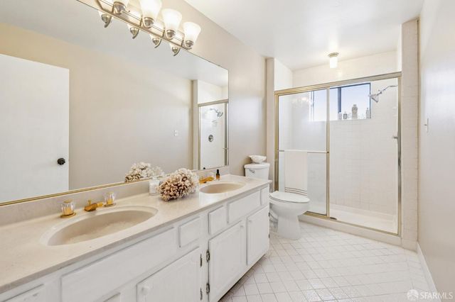 a bathroom with a double vanity sink mirror and toilet