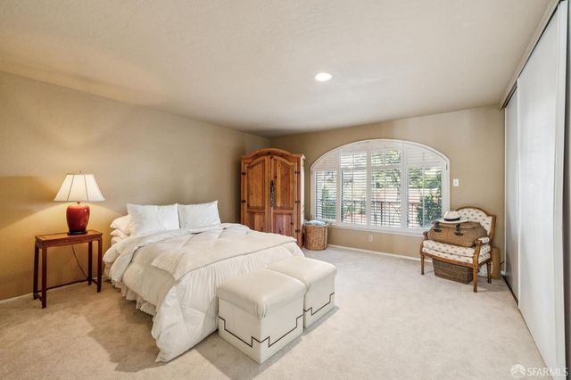 a spacious bedroom with a bed and a large window
