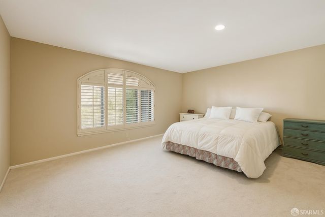 a large bed sitting in a room next to a window