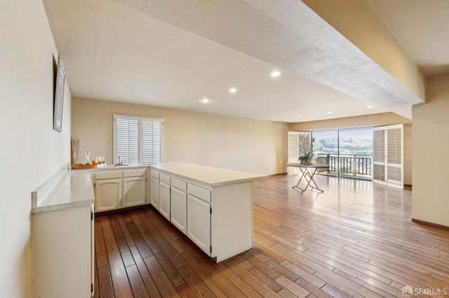 a kitchen with wooden floors and white walls