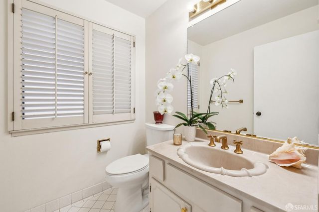 a bathroom with a sink a toilet and a mirror