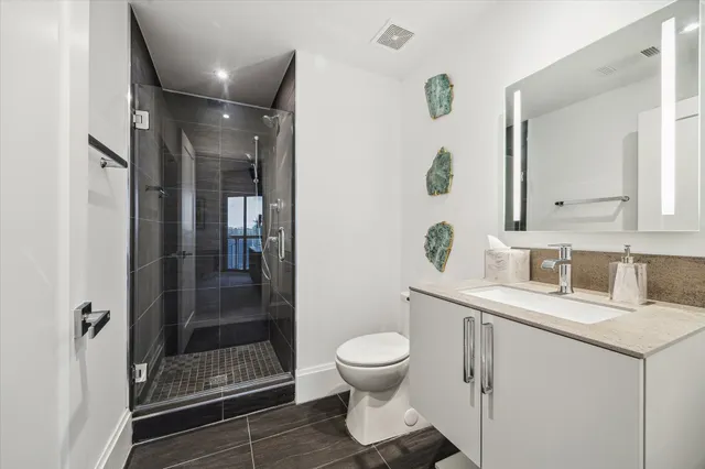 a bathroom with a toilet a sink and shower