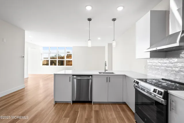 a kitchen with stainless steel appliances granite countertop a stove a sink and a refrigerator