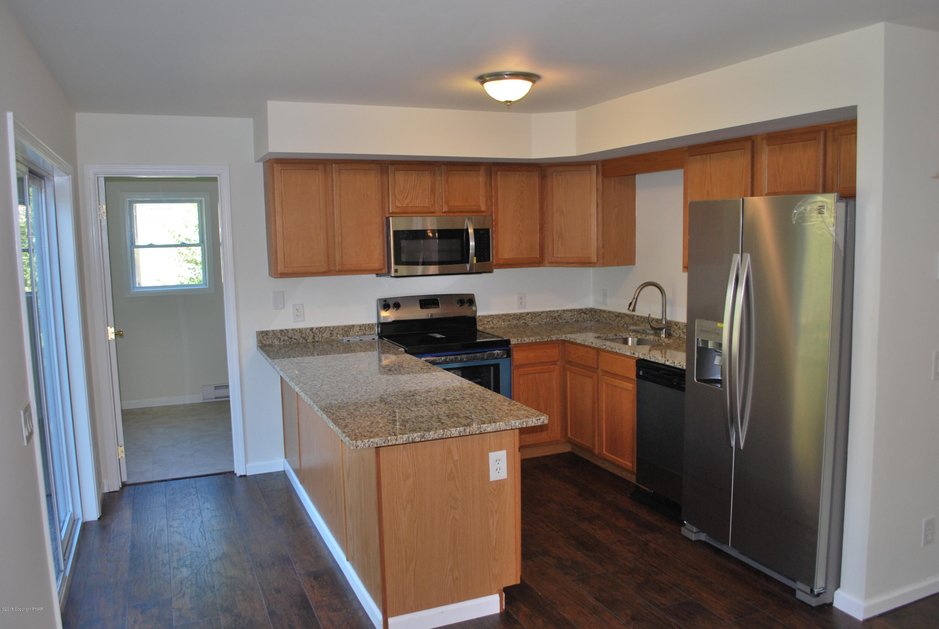 157 Magic Mountain Road Henryville, PA 18332 - Photo 2 of 29 a kitchen with a refrigerator sink and wooden cabinets
