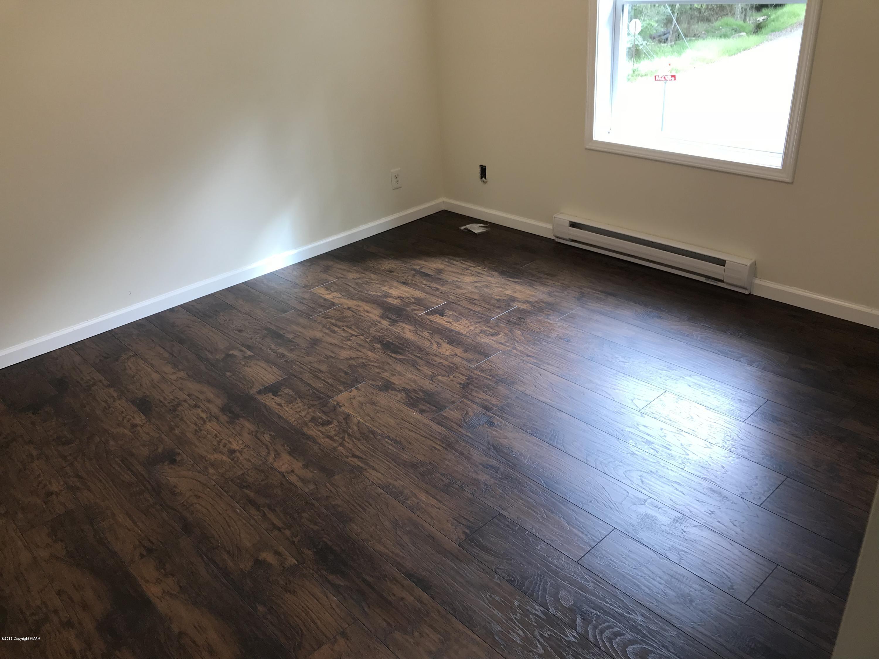 157 Magic Mountain Road Henryville, PA 18332 - Photo 22 of 29 an empty room with wooden floor and windows